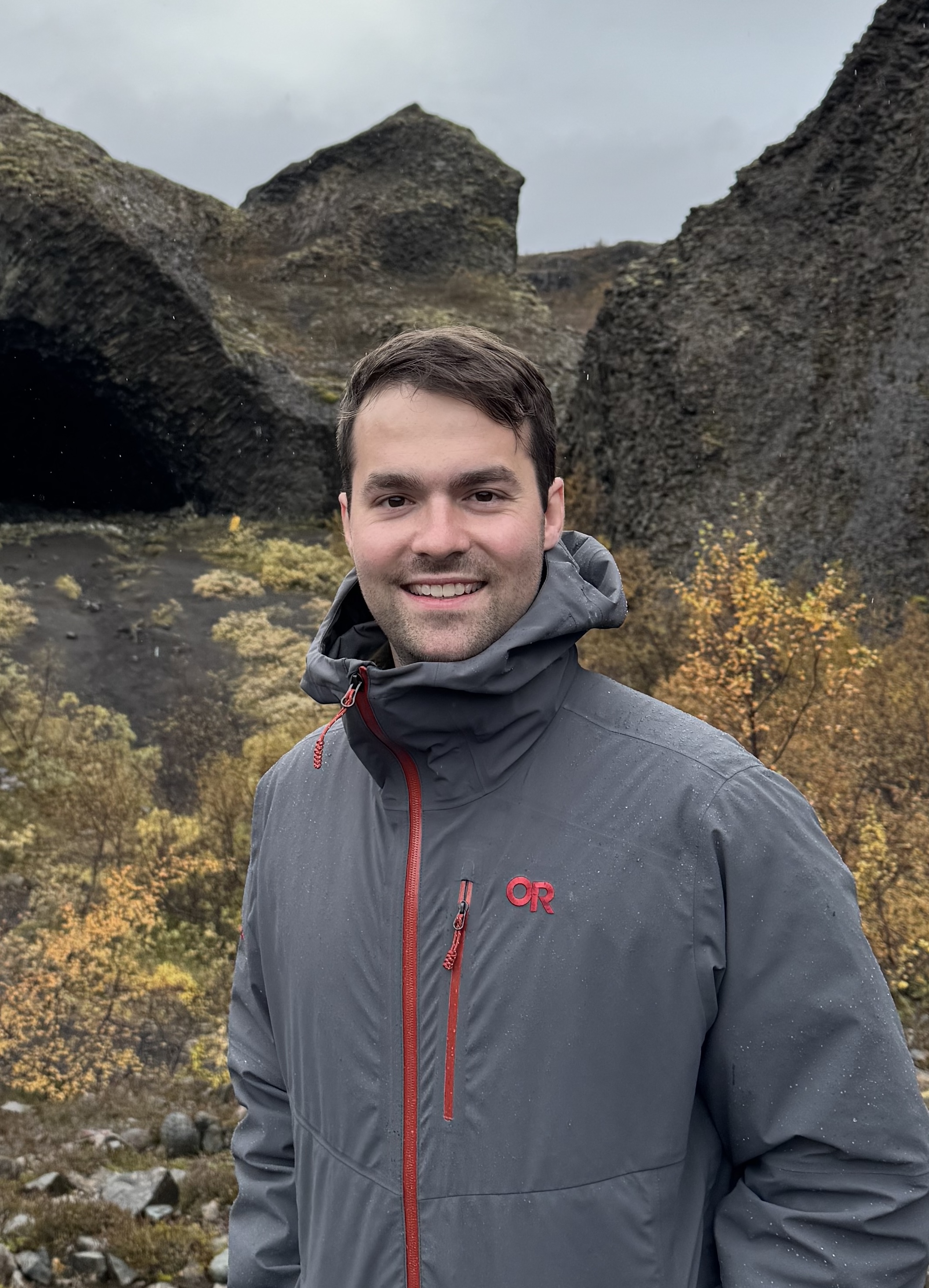 Zach Geier in Iceland in front of rocks